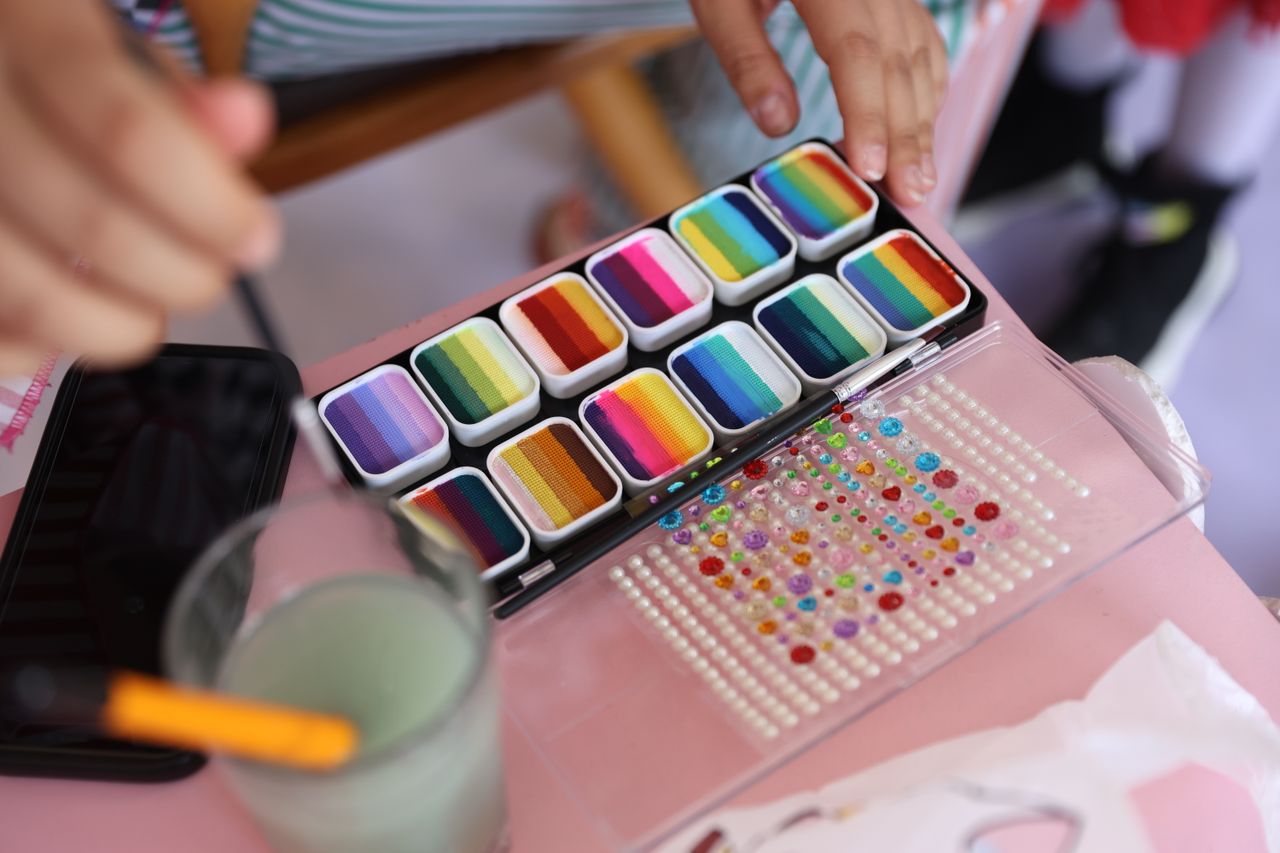 Colorful paint set and beads on table inspire creativity and crafts.