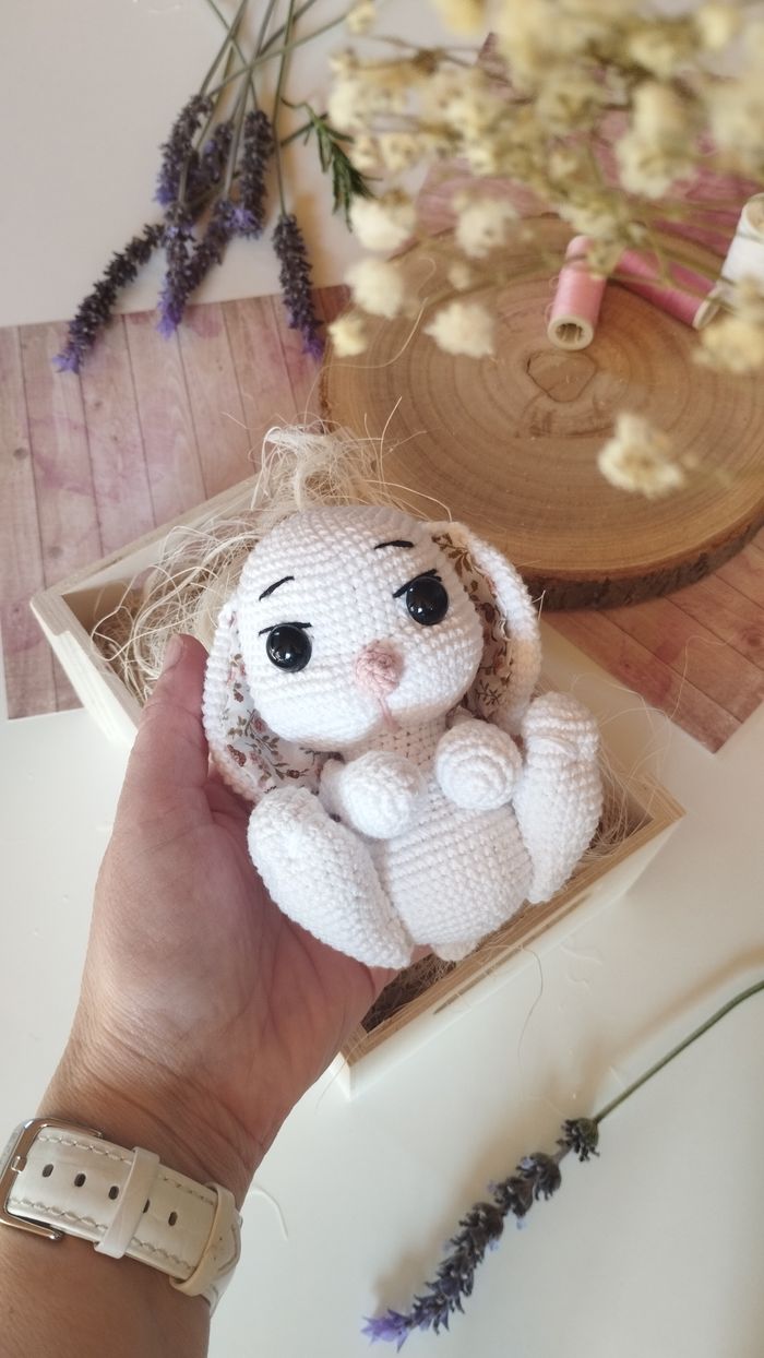 Cute crochet bunny toy in a creative flat lay with lavender and wooden textures.
